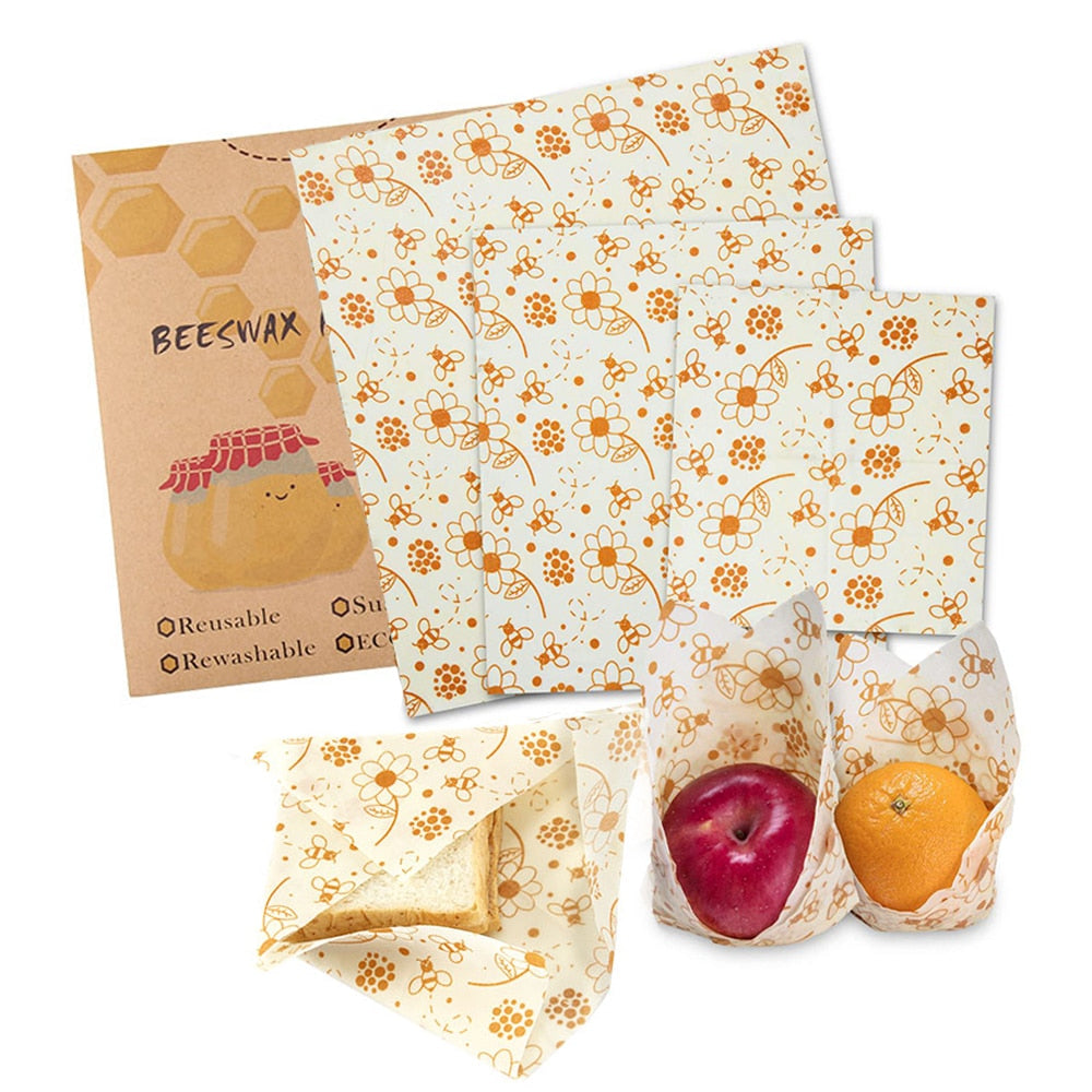 Beewrap - Lot de 3 sachets en cire d'abeille, 3 tailles différentes, motif fleur et abeille orange, une pomme et une orange emballée dans le beewrap - PBS - Naturopathie & Zéro déchet